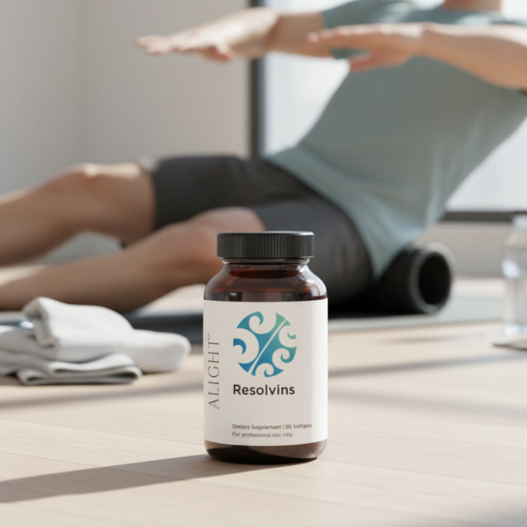 Bottle of ALIGHT Resolvins supplement on a table with a person stretching in the background