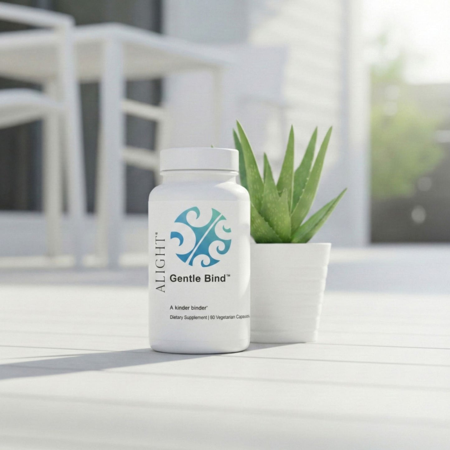 Supplement bottle labeled 'Gentle Bind' by 'ALIGHT' on a white surface with a plant in the background.