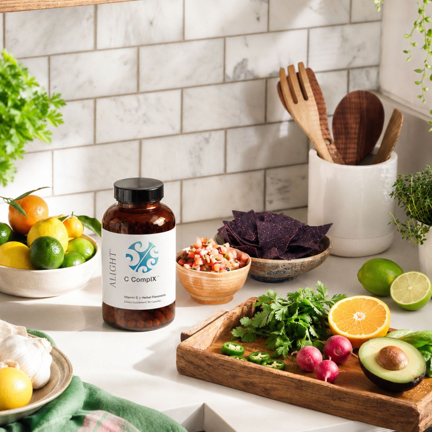 A bottle of Aight C Complex dietary supplement placed on a kitchen counter surrounded by fresh fruits, vegetables, and wooden utensils.