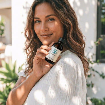 woman holding ParXpel bottle outdoors smiling at camera