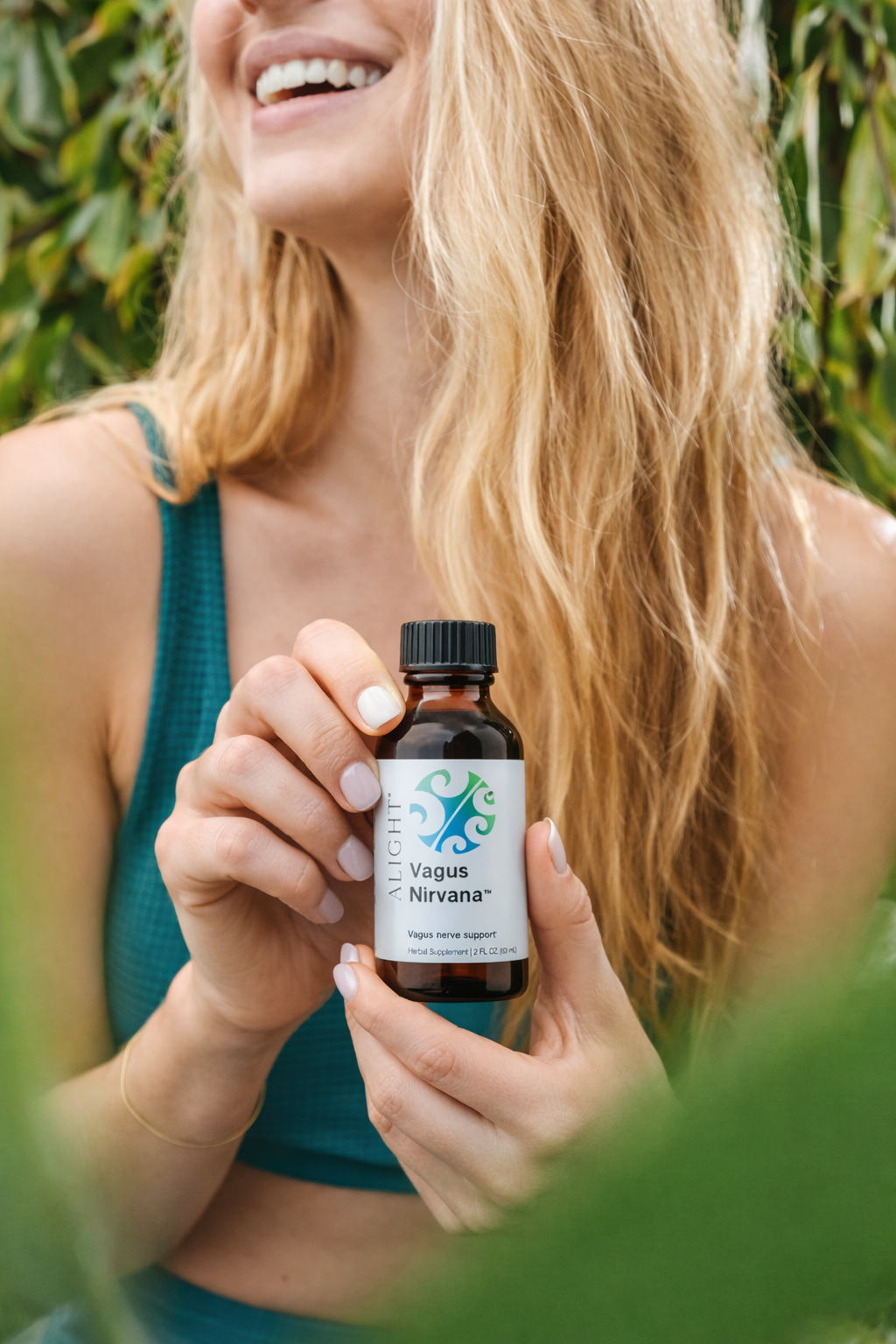 Woman holding a bottle labeled 'Vagus' against a natural background