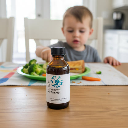 Bottle of 'Yummy Tummy' supplement on a table with a child eating in the background