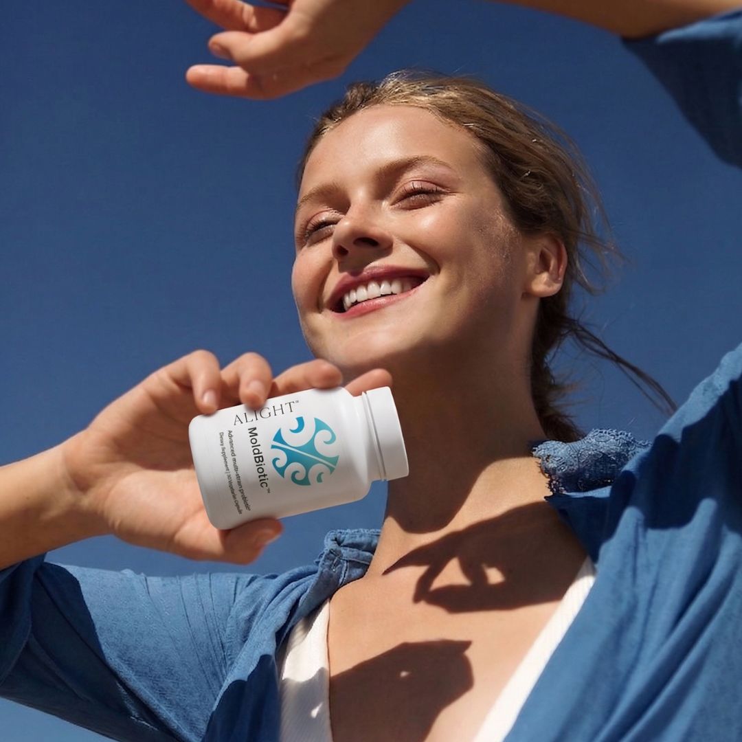 Woman holding a supplement bottle with a clear blue sky background